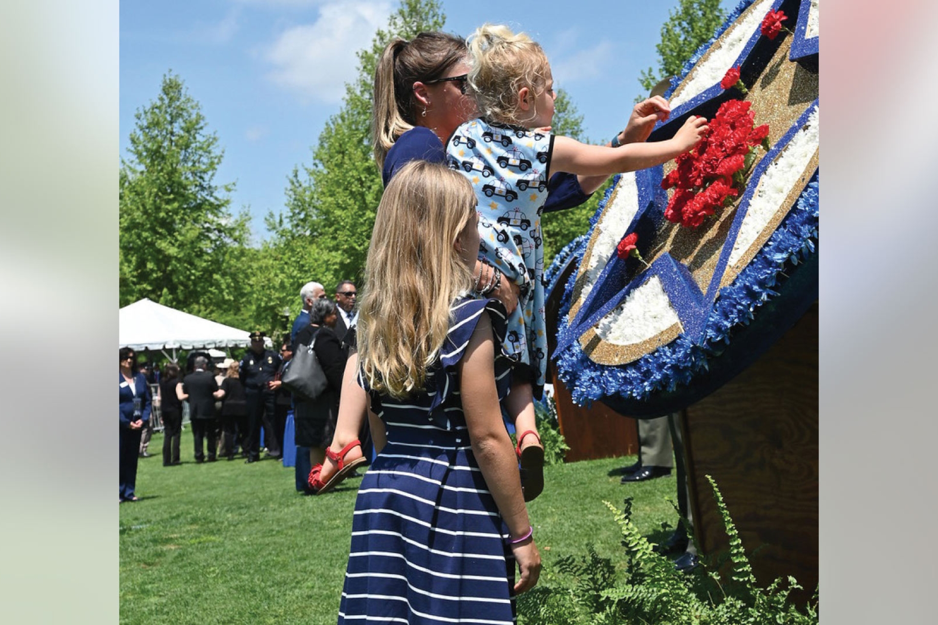national-police-week-2022-9-a-family-places-a-flower-in-the-wreath-at-the-memorial-service